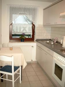 cocina con mesa, fregadero y ventana en Ferienwohnung Thiele, en Wettelrode