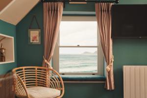 a room with a window with a view of the ocean at The Old Success Inn in Sennen Cove