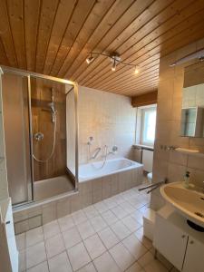 W łazience znajduje się prysznic, wanna i umywalka. w obiekcie Forsthaus Reit im Winkl w mieście Reit im Winkl