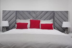 a bedroom with a large bed with two red pillows at Alegria Dream Home in Funchal