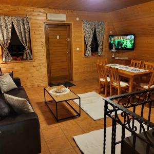 a living room with a couch and a table at Domki Bieszczady Siedlisko Harenda in Czarna