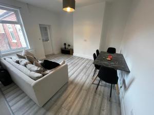 a living room with a couch and a table at Spacious 4-Bedroom House in Manchester in Manchester