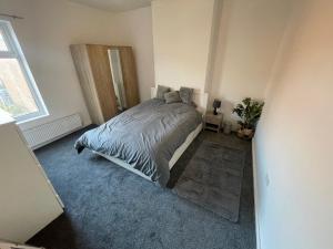 ein Schlafzimmer mit einem großen Bett in einem Zimmer in der Unterkunft Spacious 4-Bedroom House in Manchester in Manchester