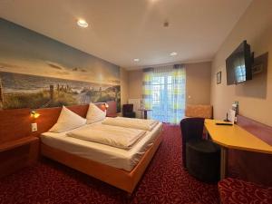 阿勒斯貝格的住宿－羅斯湖酒店，配有一张床和一张书桌的酒店客房