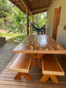 - une table de pique-nique en bois sur une terrasse avec un hamac dans l'établissement Vila dos Anjos Itacaré, à Itacaré