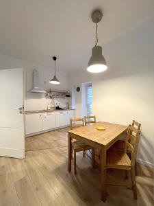 cocina y comedor con mesa de madera y sillas en 24 Gdynia Centrum - Apartament mieszkanie dla 4 osób, en Gdynia