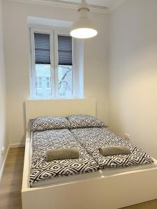 1 cama blanca con 2 almohadas en el dormitorio en 24 Gdynia Centrum - Apartament mieszkanie dla 4 osób, en Gdynia