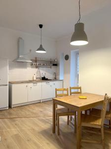una cocina con mesa de madera y sillas. en 24 Gdynia Centrum - Apartament mieszkanie dla 4 osób, en Gdynia