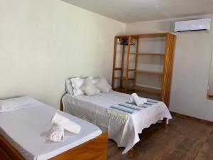 Cette petite chambre comprend 2 lits et une étagère. dans l'établissement Vila dos Anjos Itacaré, à Itacaré