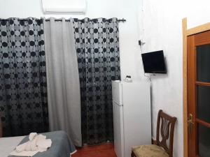 a small room with a refrigerator and a curtain at Molino de Lucero, casa rural in Teba