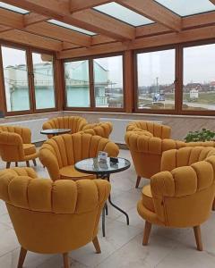 沙巴茲 Š的住宿－Smestaj & Spa Protić，一间设有黄色椅子和桌子的等候室