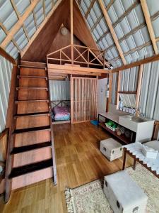 Cama elevada en habitación con escalera en Palanta Roemah Kajoe Syariah Villa, en Kampungdurian
