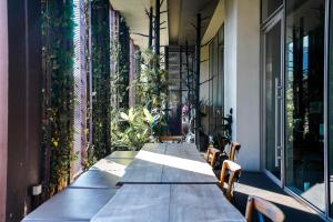 a long table on the side of a building with plants at Thonglor Modern Luxury Condo in Bangkok