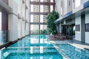 a pool in the middle of a building with windows at Thonglor Modern Luxury Condo in Bangkok