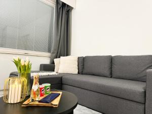 a living room with a gray couch and a table at Aurora City Studio By BookLapland in Rovaniemi