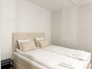 a bedroom with two beds with white sheets and pillows at Aurora City Studio By BookLapland in Rovaniemi