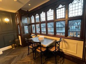 a table and chairs in a room with windows at Eastgate Rows Apartments in Chester