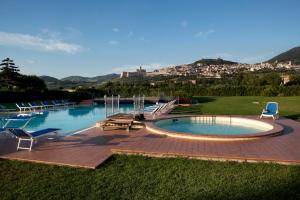 a large swimming pool with chairs at Hotel Bellavista in Assisi