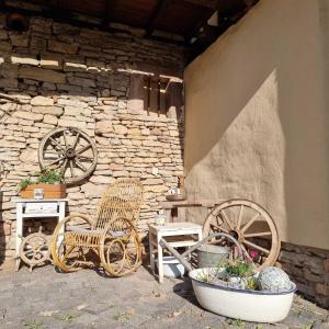 a patio with two chairs and a table and a stone wall at Pension Stadtmühle Allstedt in Allstedt