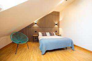 1 dormitorio con 1 cama y 1 silla azul en VUT en centro histórico de Burgos con parking incluido ATUAIRE, en Burgos