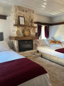 a bedroom with two beds and a stone fireplace at la foret in Metsovo