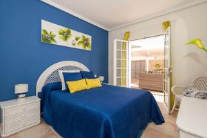 a blue bedroom with a bed with yellow pillows at Villa Vanesa luxury private villa with a heated pool, 4 bedrooms and 4 bathrooms in Adeje +120 photos
