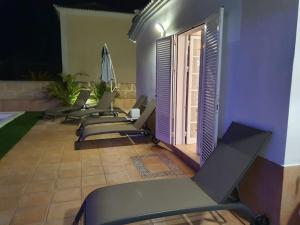 a row of chairs lined up next to a building at Villa Vanesa luxury private villa with a heated pool, 4 bedrooms and 4 bathrooms in Adeje