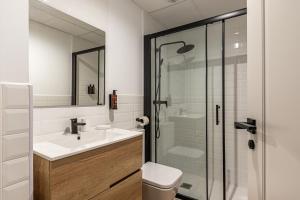 La salle de bains blanche est pourvue d'un lavabo et d'une douche. dans l'établissement BNBHolder Best VI Madrid Rio, à Madrid