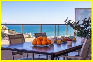 una mesa con naranjas y vistas al océano en Cullera Beach Apartment Cap Blanc, en Cullera