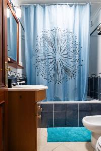 een badkamer met een blauw douchegordijn en een bad bij Penthouse Olhão with terrace in Olhão
