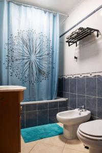 een badkamer met een blauw douchegordijn en een toilet bij Penthouse Olhão with terrace in Olhão +22 foto's