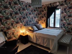 a bedroom with a large bed with floral wallpaper at Guesthouse Lokinlaulu in Kotka