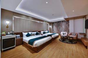 um quarto de hotel com uma cama grande e uma cadeira em Quality Inn Elite, Amritsar em Amritsar