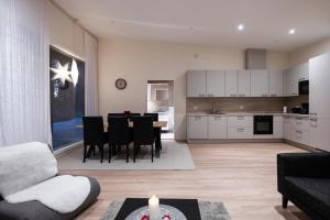 a living room and kitchen with a table and chairs at Brand new Arctic snowstar apartment in Rovaniemi