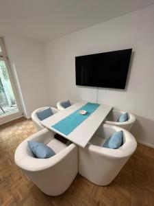 - un salon avec une table et des chaises blanches dans l'établissement Apartment BERNSTEIN ruhig, familienfreundlich mit Garten, à Rostock