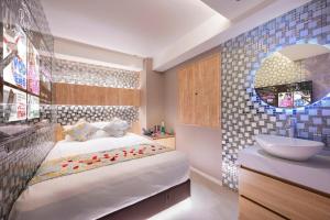 a bedroom with a bed and a sink and a bathroom at Exquisite business hotel Bella in Tokyo