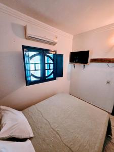 a bedroom with a bed and a window at Casa da Mãe Barra Grande in Maragogi