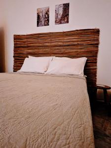 a bedroom with a large bed with a wooden headboard at Casa da Mãe Barra Grande in Maragogi