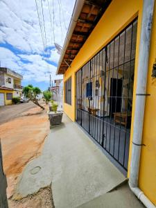 an entrance to a yellow building with a black gate at Casa da Mãe Barra Grande in Maragogi