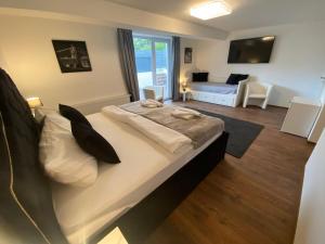 a bedroom with a large bed and a living room at ROYAL OCEAN Ferienhaus mit Sauna, Spielekonsole und Whirlpool in Rostock