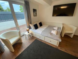 a bedroom with a bed and a chair and a window at ROYAL OCEAN Ferienhaus mit Sauna, Spielekonsole und Whirlpool in Rostock