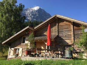 una cabaña de madera con una montaña en el fondo en Eigerhome - The Cottage mit Wellness - GRIWA RENT AG, en Grindelwald