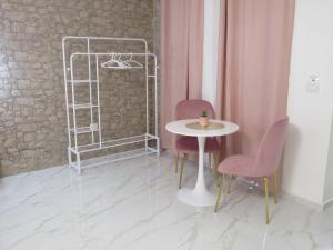 a table and two chairs and a white table and a shelf at Tortora house in Naples