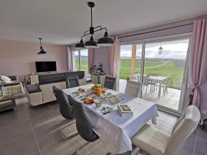 a dining room with a table and a living room at Chambre de Bajolle in Fourcès
