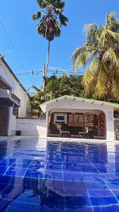 a pool in front of a house with a palm tree at Hotel Quinta Ana María in Melgar