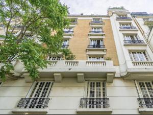 un alto edificio bianco con finestre e balconi di Magnifique Appartement de luxe & familial avec Parking - Paris 16 a Parigi