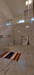 baño de mármol con lavabo y aseo en The Connoisseur, en Baihar