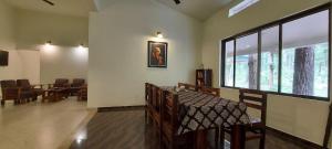 una sala de espera con mesas y sillas y una ventana en The Connoisseur, en Baihar