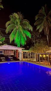 uma piscina azul com palmeiras ao fundo em Hotel Quinta Ana María em Melgar