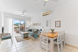 a dining room and living room with a table and chairs at Limnaria Gardens Cozy Apartment in Paphos City